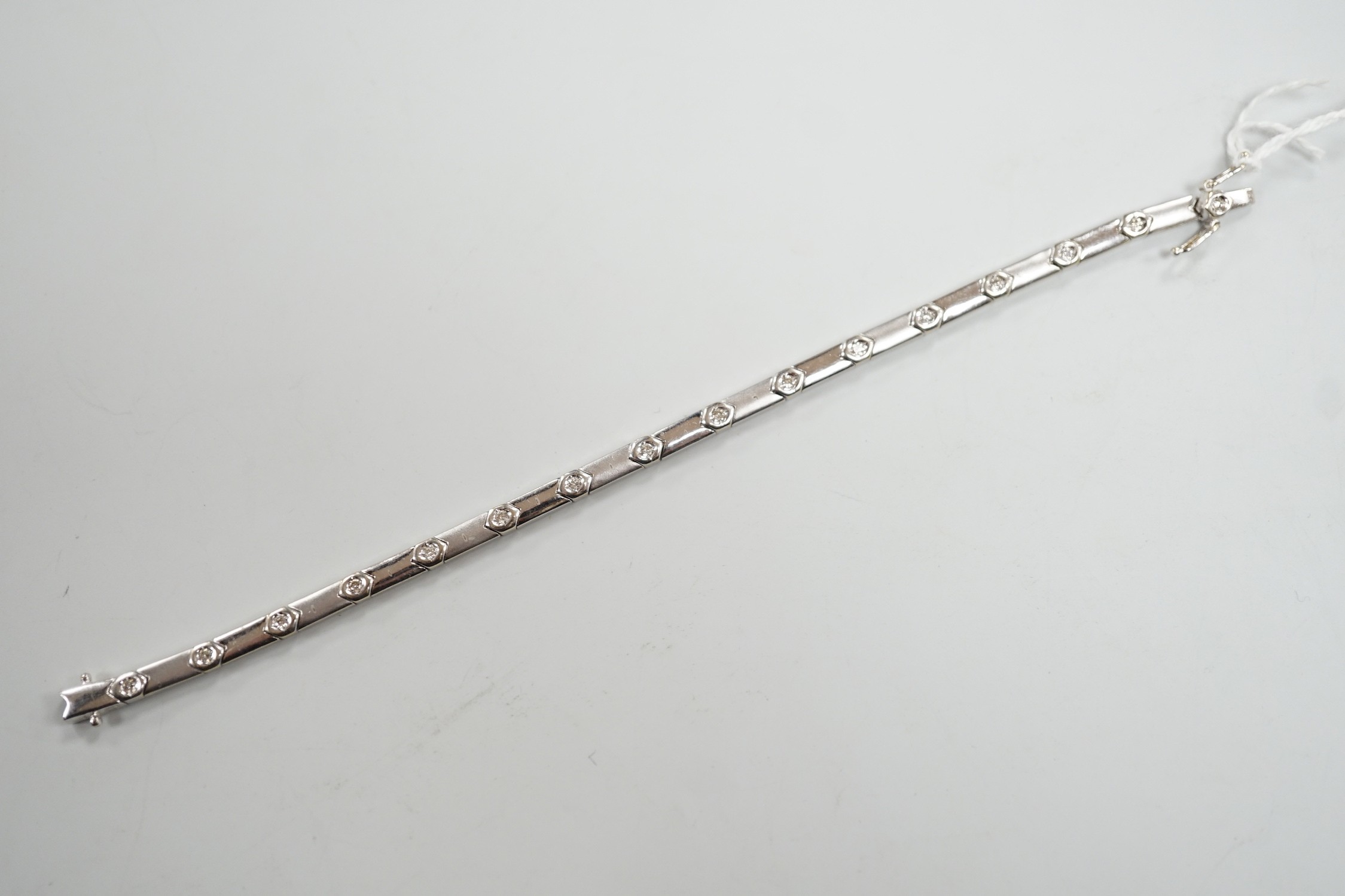 A modern 18k white metal and diamond chip set line bracelet, 15cm, gross weight 10.4 grams.